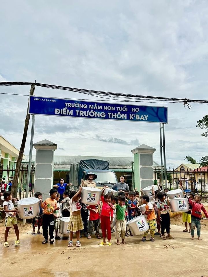 Kindergarten children holding HOPE cooking pots outside their school in Vietnam